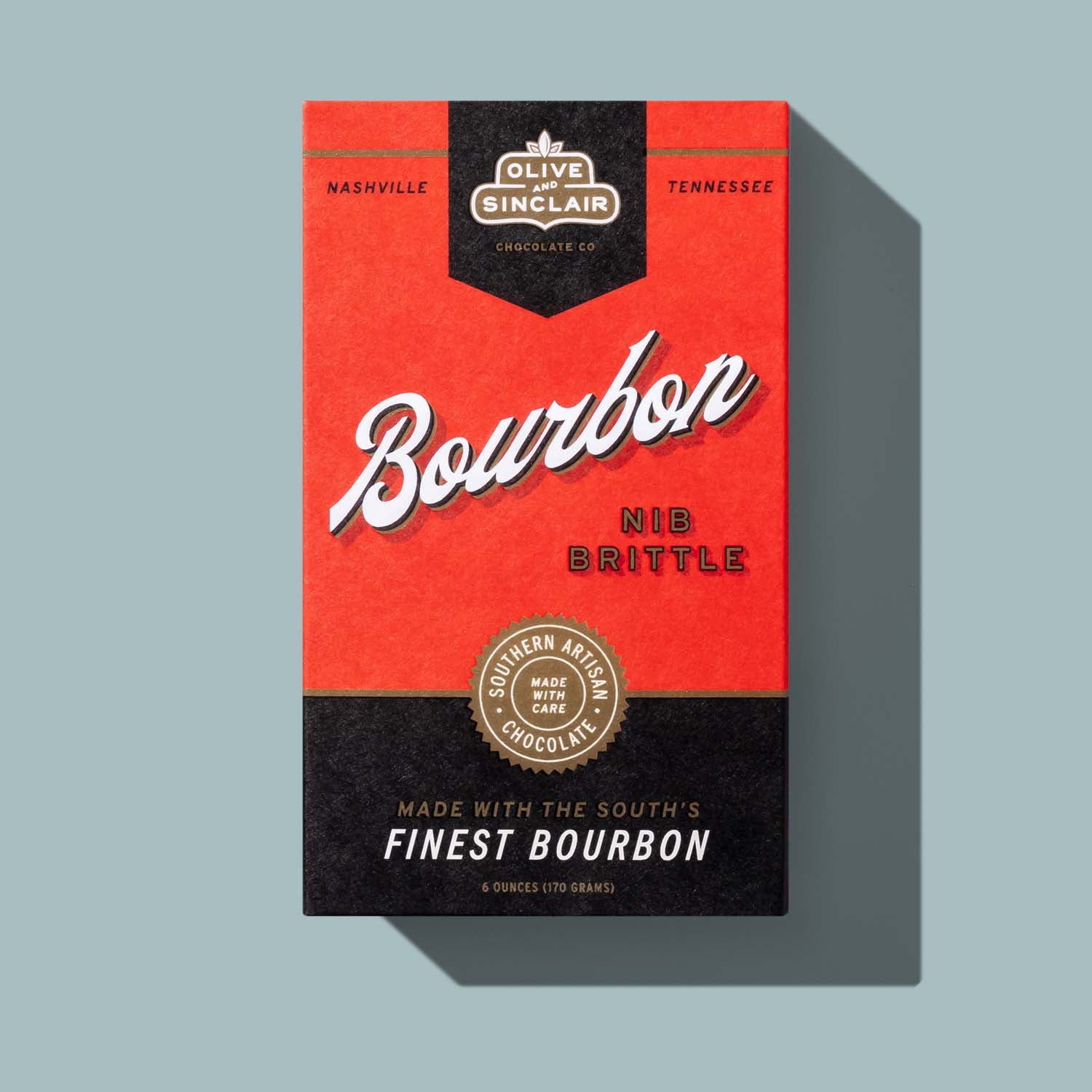 Red and black packaging of Bourbon Nib Brittle with 'Olive & Sinclair' branding on a light gray background.