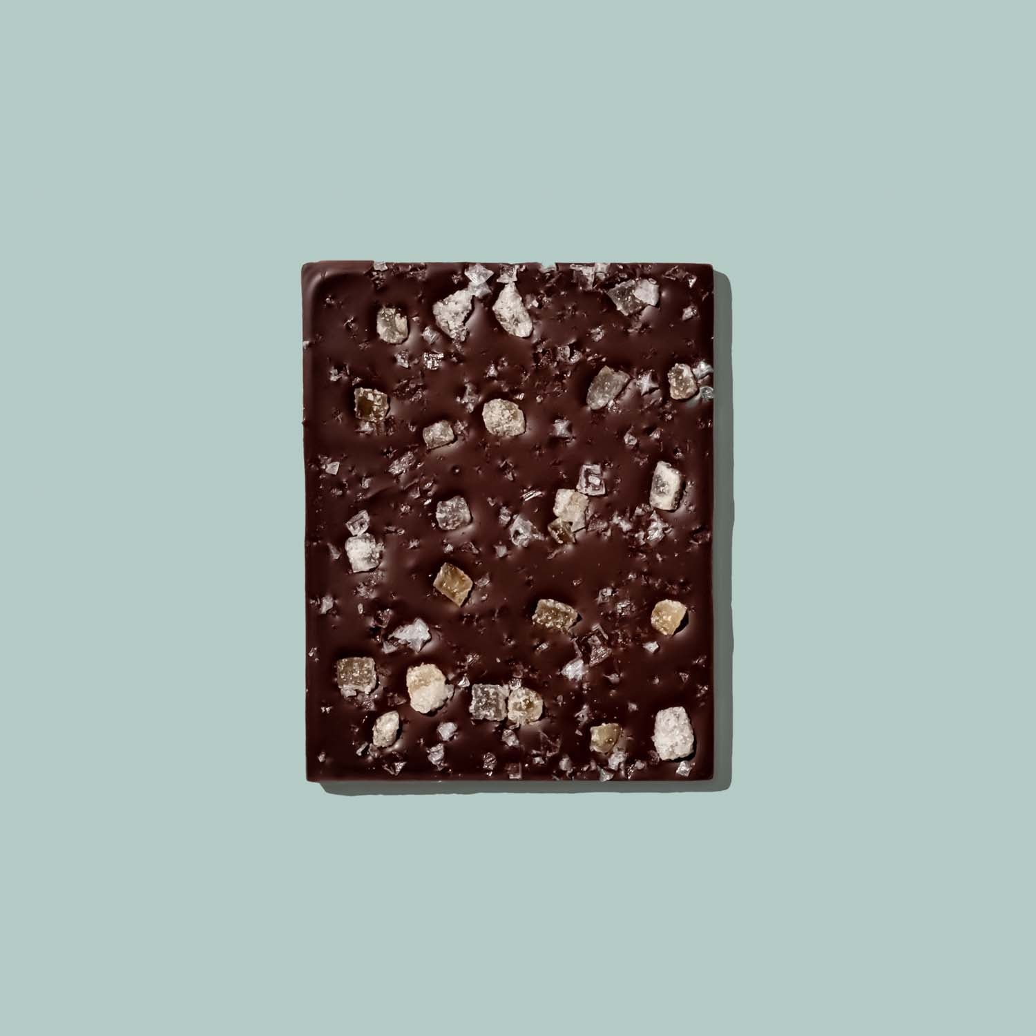 Dark chocolate bar with visible chunks on a light blue background