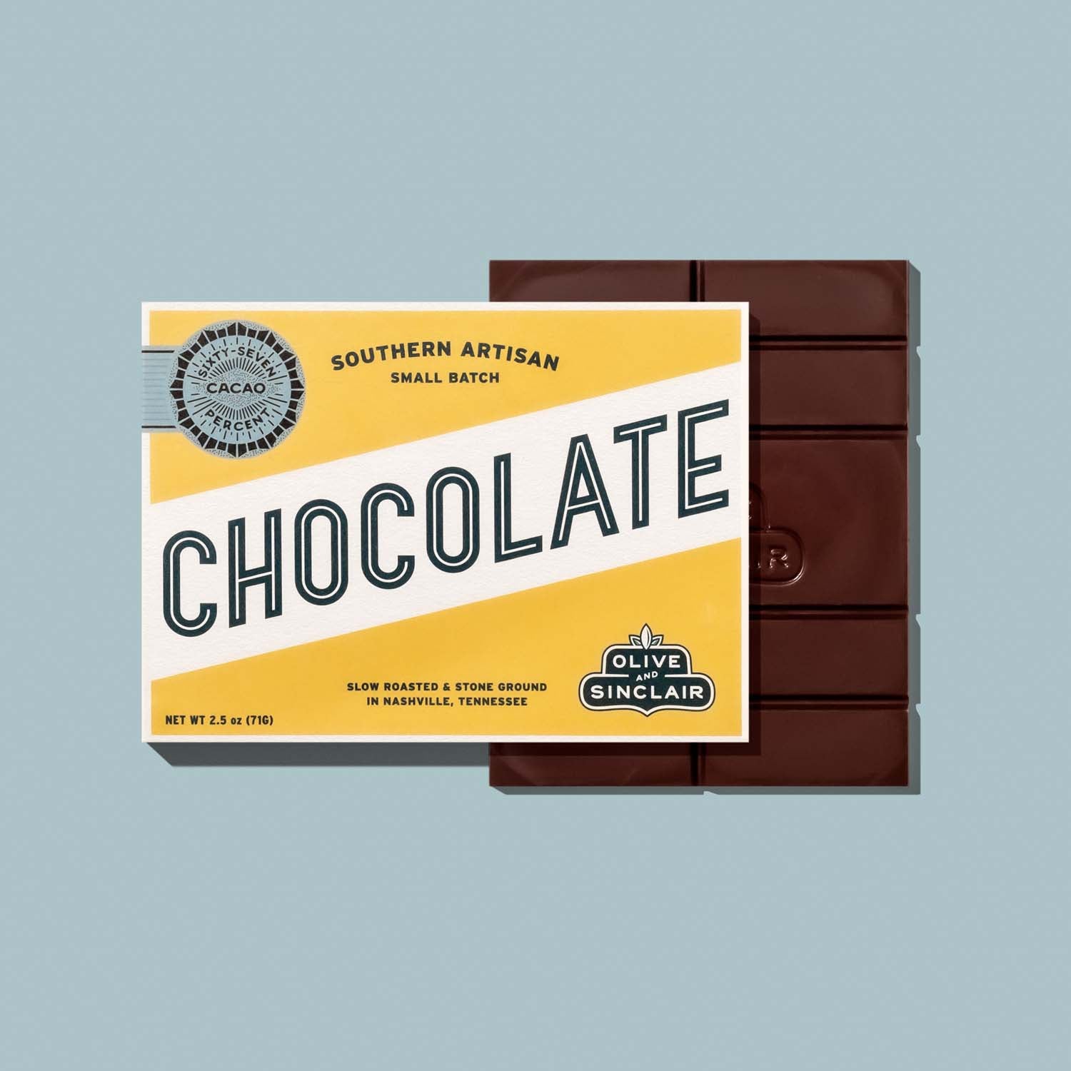 Chocolate bar with a yellow packaging featuring 'Olive Sinclair' branding on a light blue background.