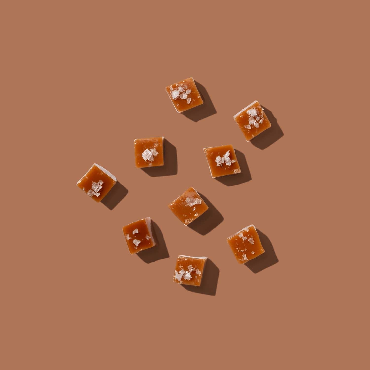 Caramel squares with sea salt on a brown background